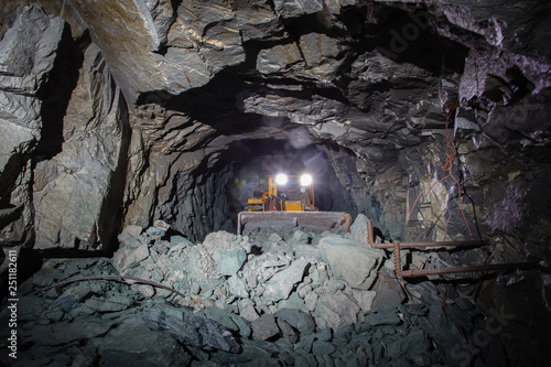 Underground gold ore mine shaft tunnel gallery passage with load, haul, dump machine LHD photo