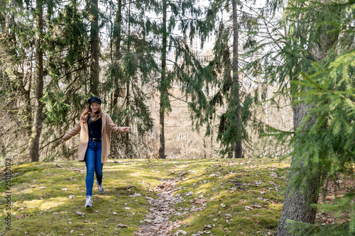  Beautiful girl in a coat runs through the woods. Happiness, freedom, zen concept