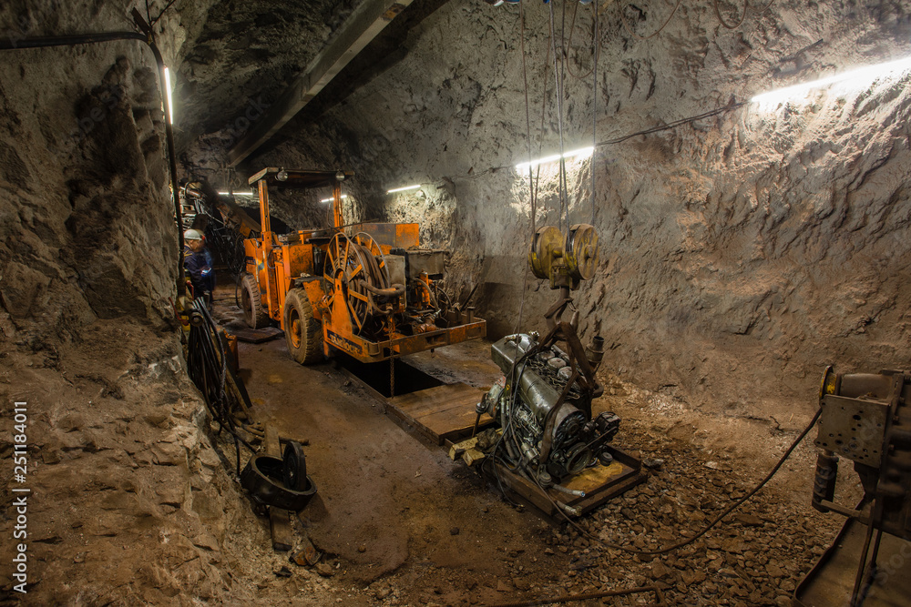 Underground gold ore mine shaft tunnel gallery passage with drilling rig
