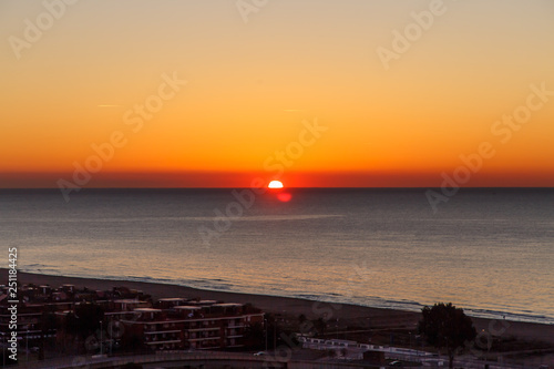 The sun rises (sunrise) over the sea, early morning