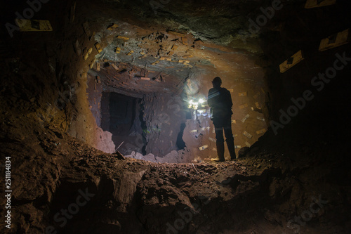 Underground gold ore mine shaft tunnel gallery passage with miner