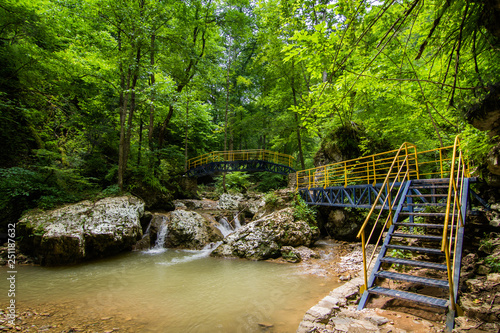 metal stairs and bridge over a mountain river in the forest on a Sunny day