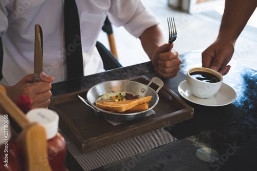 A man eating a healthy morning meal, breakfast at cafe. Businessman with breakfast.