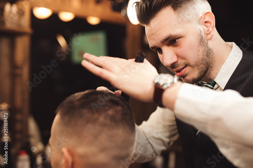 Professional haircut with scissor in a male barbershop salon