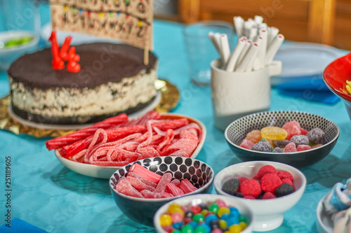 Colorful sweets on birthday table with blue tablecloth © Nedrofly