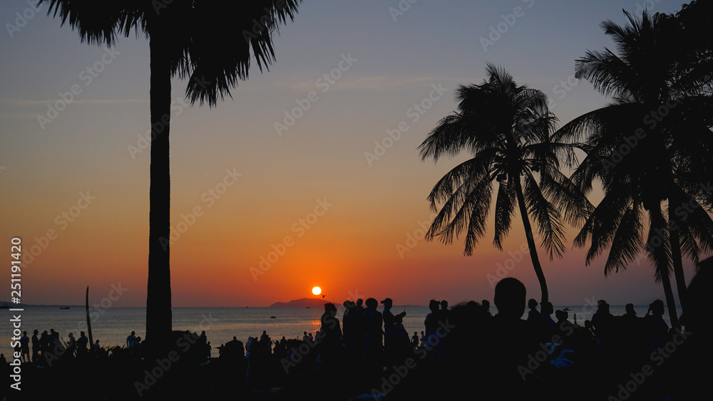 Obraz premium Silhouetted People Relaxing on Sunset Beach. Travel concept