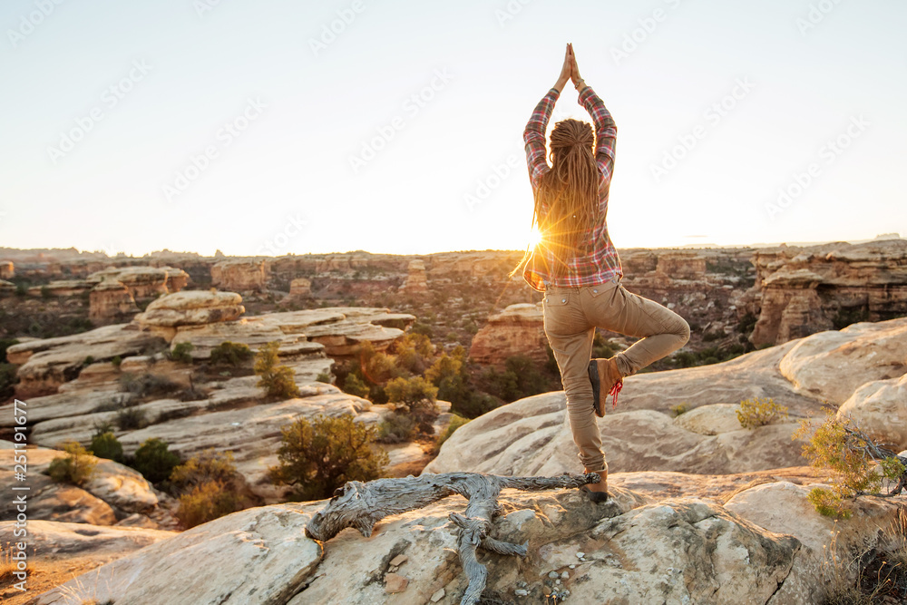 Young woman is practicing yoga at mountain - obrazy, fototapety, plakaty 
