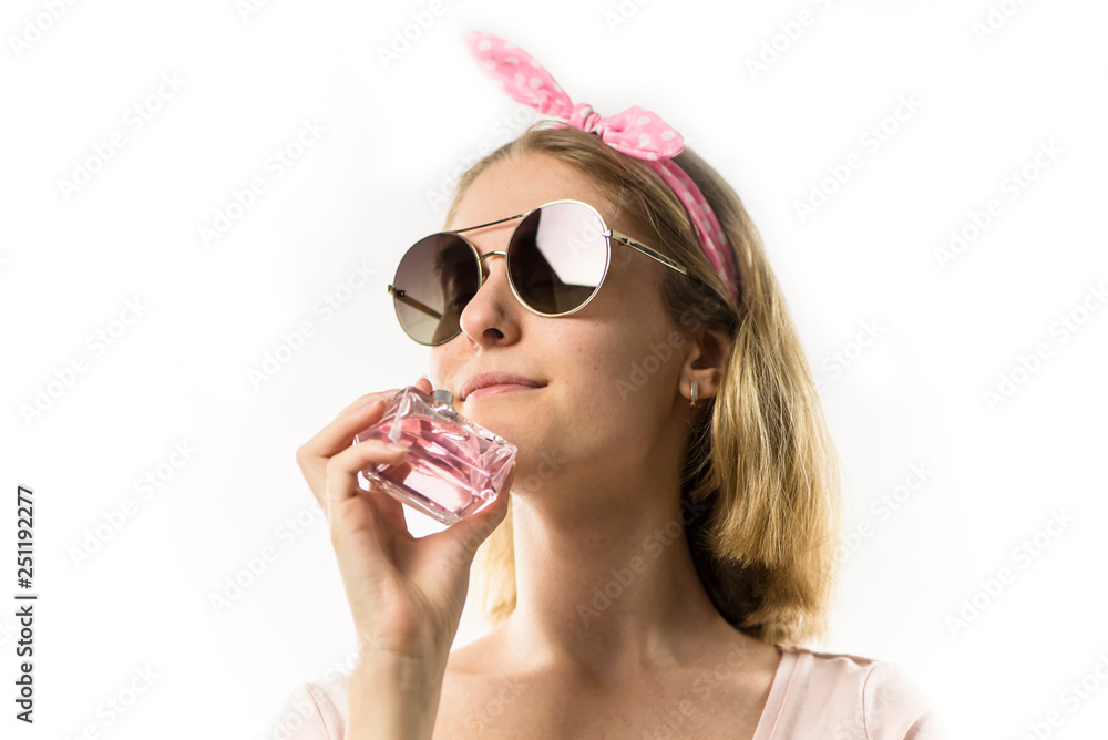 Fototapeta premium całkiem stylowa blondynka trzymając butelkę modnych perfum na białym tle