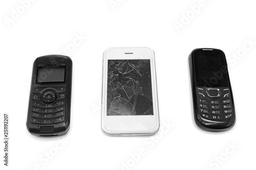 The new generation smartphone lies next to the push-button phone on an isolated background . Mobile technology development 