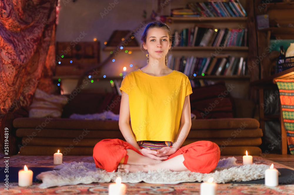 Close-up of woman's hand in yoga lotus pose meditating in a crafting room with candles