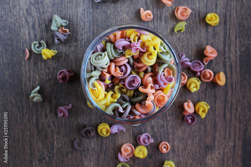 Jar of colored pasta on a wooden table