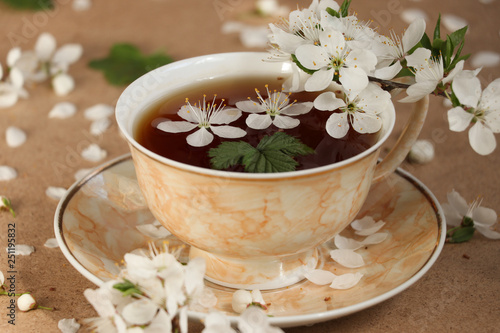 Spring, delicious, delicate tea with cherry flowers and raspberry leaves in a light brown cup