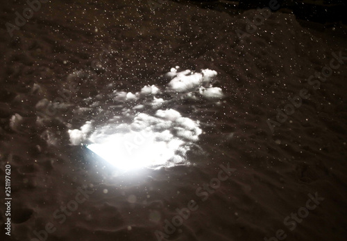 Light of a lantern in the snow as a background