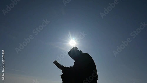 man in hoodie with mediapad silhouette camera slow motion up