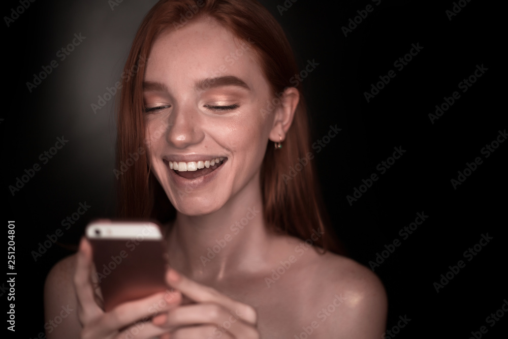 The portrait of a young redhead lady isolated over a black background The portrait of a young redhead lady isolated over a black background