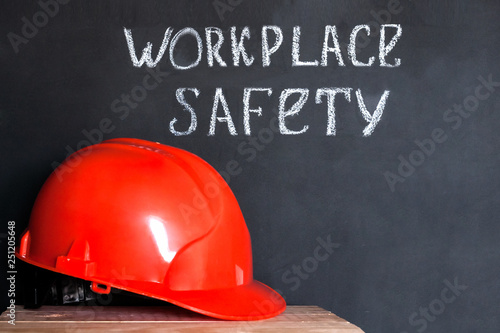 Construction helmet on a black background with the inscription workplace safety . Safety concept