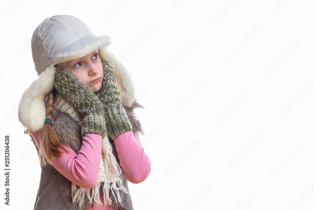 Winter Kids Fashion, Clothing And Holidays Ideas. Sad Looking Caucasian Girl In Pink Vest and White Winter Hat, Scarf and Mittens.Looking Upwards Over Pure White.