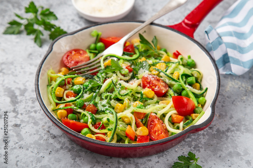zucchini noodle with tomato, corn and green peas on pan, healthy vegan food