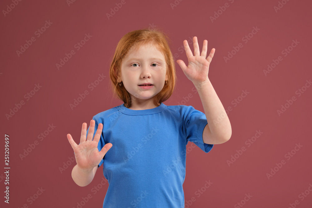 Portrait of cute redhead emotional little girl on red background Portrait of cute redhead emotional little girl on red background
