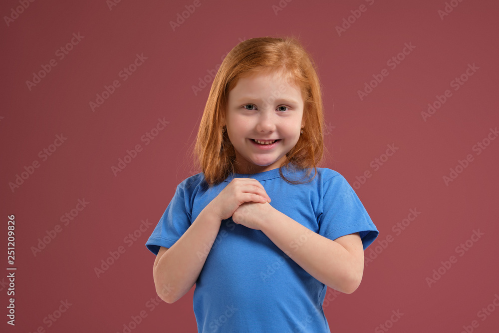 Portrait of cute redhead emotional little girl on red background Portrait of cute redhead emotional little girl on red background