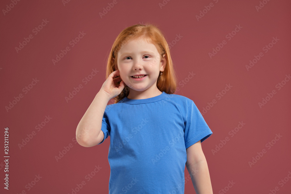 Portrait of cute redhead emotional little girl on red background Portrait of cute redhead emotional little girl on red background
