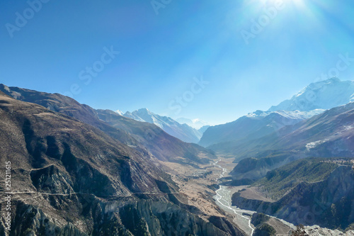 Trek in Annapurna Circuit, Himalayas, Nepal. Trail goes on from Manang along the river, those who lock back are rewarded with beautiful view on the river, reflecting rays of the rising sun. Sunrise