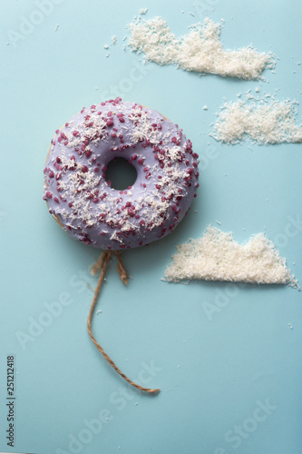 Concept purple donuts on a blue background with clouds minimalism