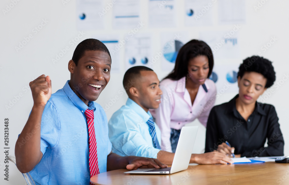 Cheering african american businessman with business team at office Cheering african american businessman with business team at office