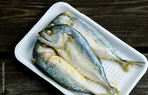 Mackerel steamed  on foam tray with wooden background. photo