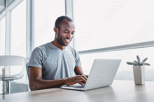 Young businessman working on his laptop in spacious bright office.