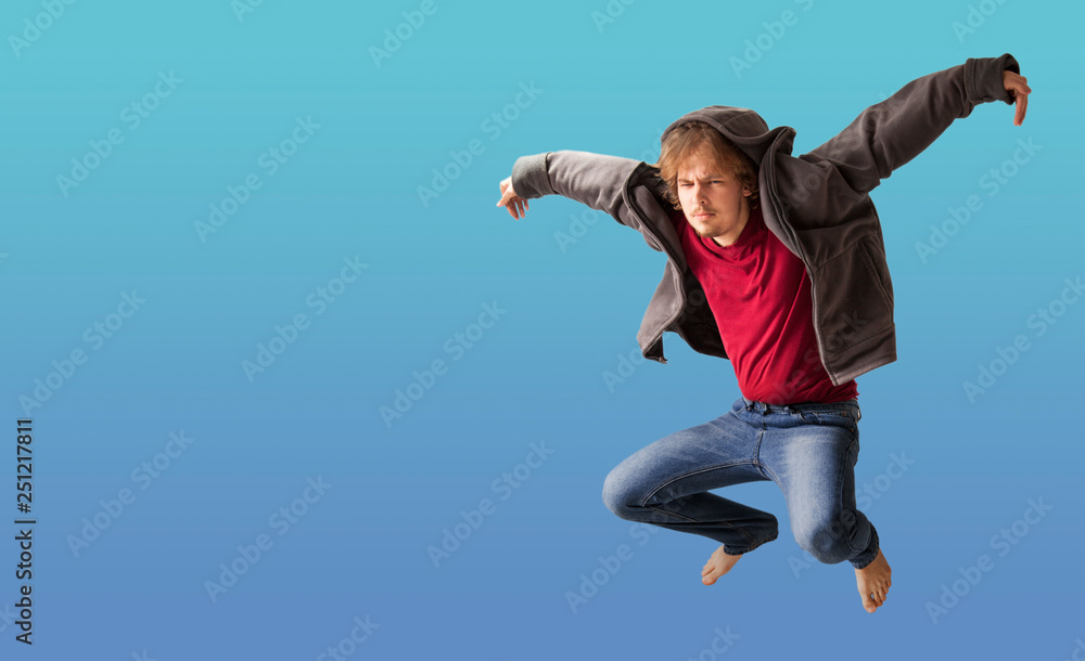 teenager boy jumping dance movement on a colored blue background teenager boy jumping dance movement on a colored blue background