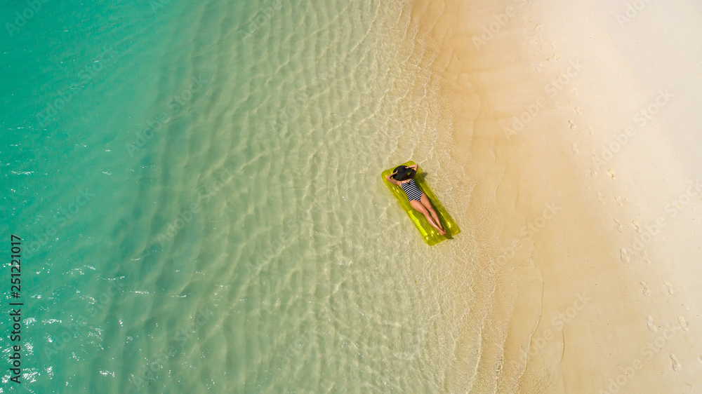 Aerial drone aerial view of Beautiful girl having fun on the sunny tropical beach. Seychelles