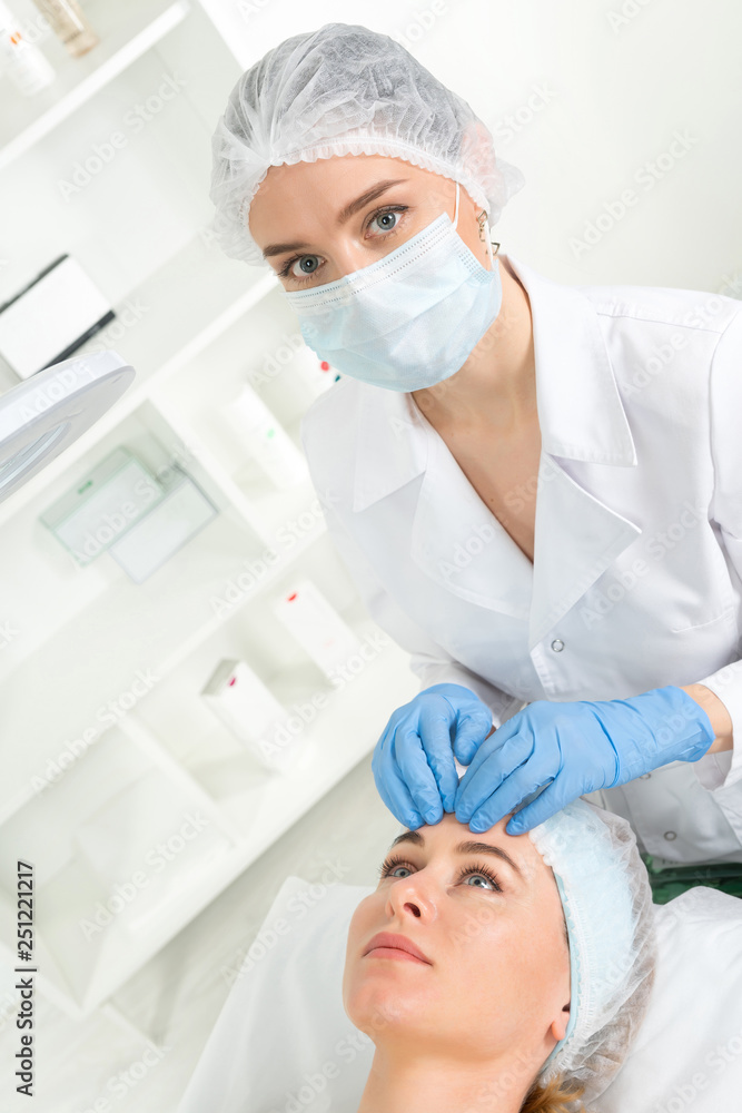 Female beautician doctor with patient in wellness center. Professional cosmetologist make procedure to beautiful girl in cosmetology cabinet or beauty parlor. Female beautician doctor with patient in wellness center. Professional cosmetologist make procedure to beautiful girl in cosmetology cabinet or beauty parlor.