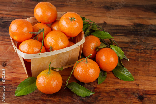 tangerines organic fruits with leaves on wooden background