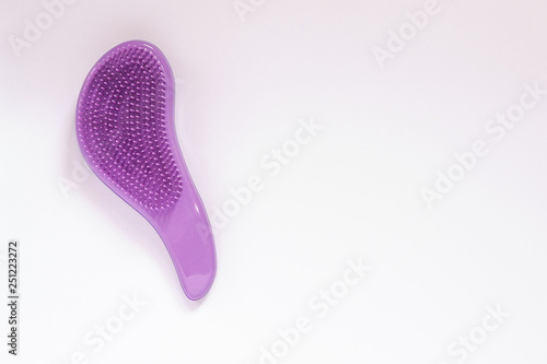 Closeup purple hairbrush for combing in period of hair fall on white background with copy space. Salon professional equipment for making hairstyle.