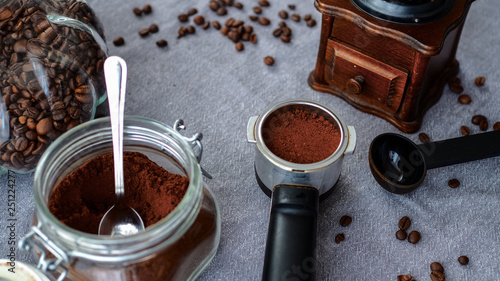 Świeżo zmielona kawa przygotowania do parzenia w otoczeniu młynka do kawy i ziarenek kawy.