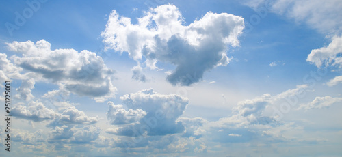 Cumulus clouds in the blue sky. Wide photo .