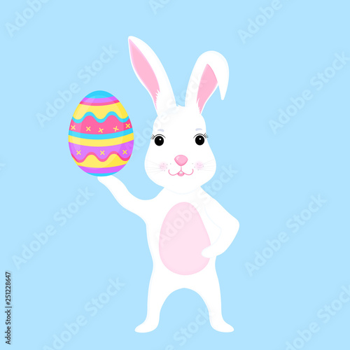 Funny easter bunny holds an paschal egg in its paw
