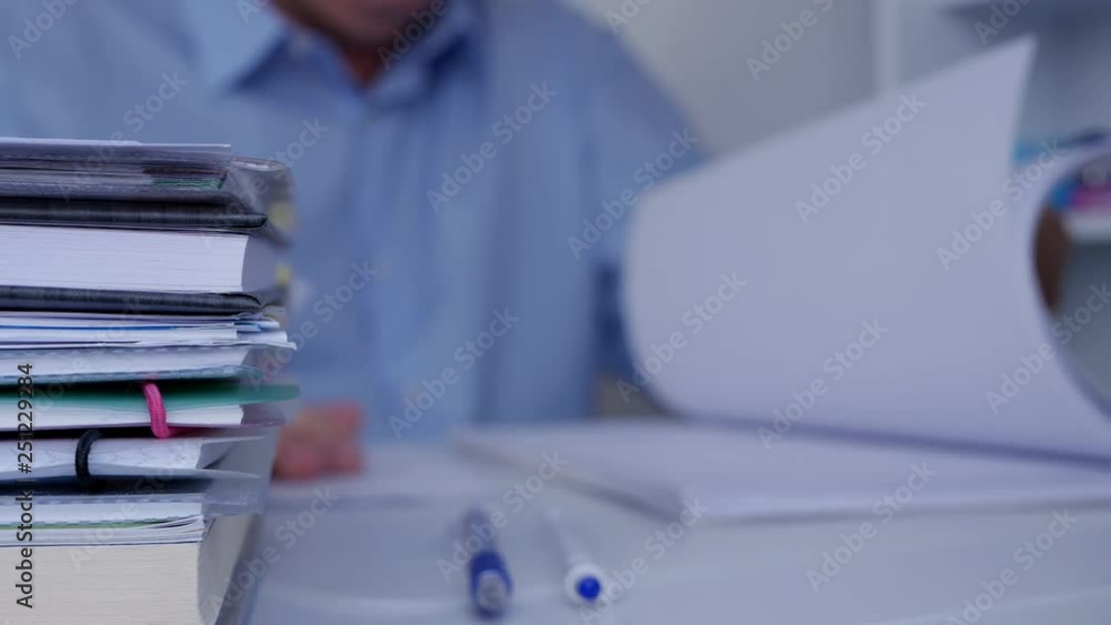 Businessman Browsing Financial Documents and Accounting Papers in Office Room Businessman Browsing Financial Documents and Accounting Papers in Office Room