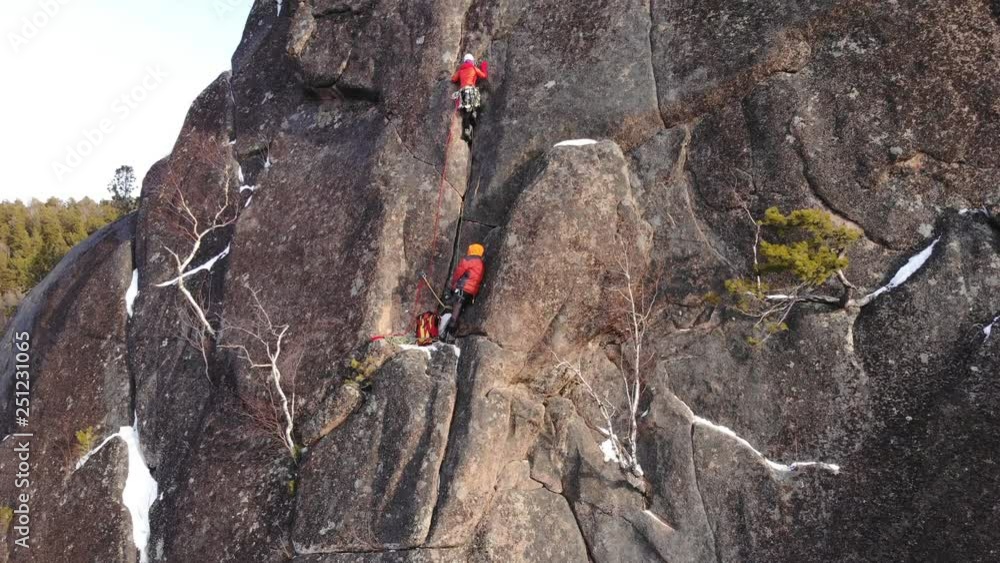 Two climbers climb the wall at high altitude. Two climbers climb the wall at high altitude.
