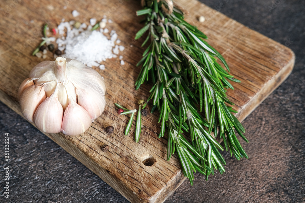 Obraz premium Fresh rosemary herb, scab and spices on a dark background copy space top view.