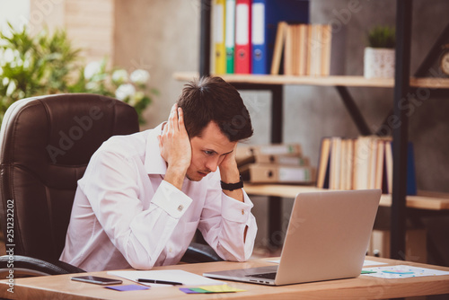 Stressed young businessman shocked by bad news using laptop at work, desperate bankrupt investor lost money, financial problem debt, tired of overwork