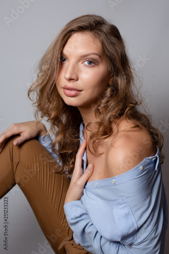 Stylish look of a sexy woman in a blue shirt. Street style studio photography. Model test