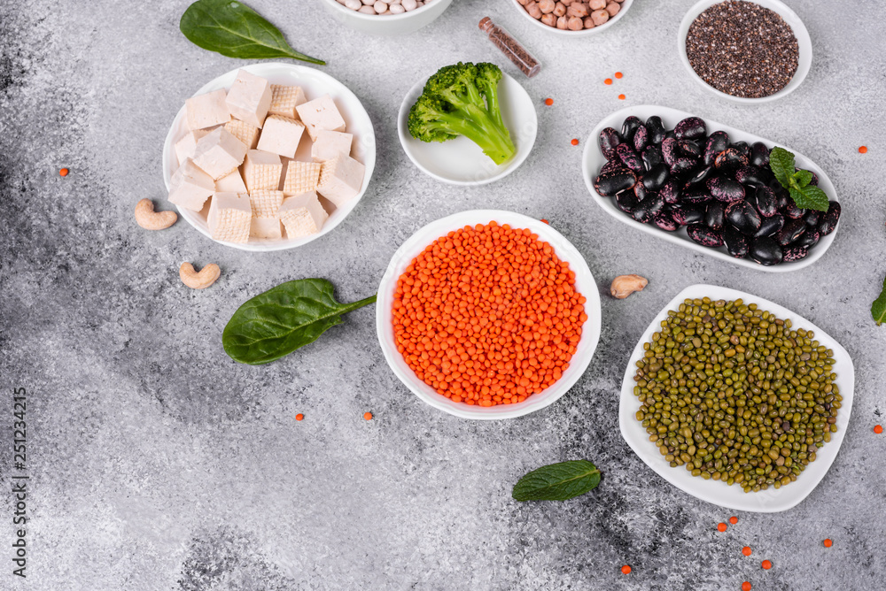 Superfoods on a gray background with copy space. Nuts, beans, greens and seeds. Healthy vegan food Superfoods on a gray background with copy space. Nuts, beans, greens and seeds. Healthy vegan food