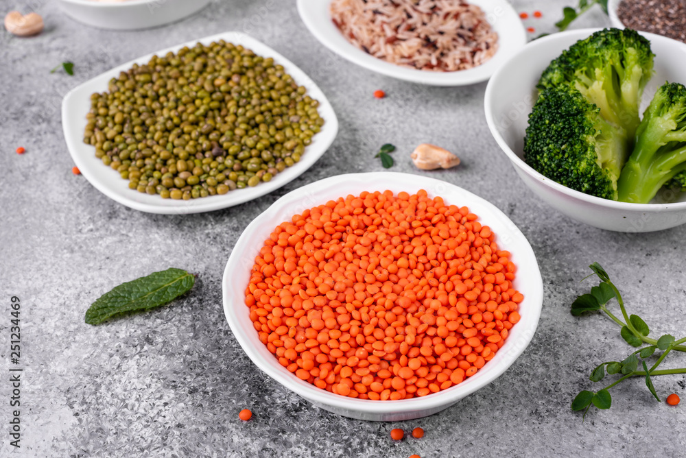 Superfoods on a gray background with copy space. Nuts, beans, greens and seeds. Healthy vegan food Superfoods on a gray background with copy space. Nuts, beans, greens and seeds. Healthy vegan food