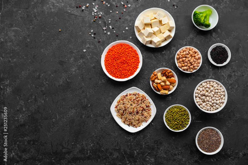 Superfoods on a gray background with copy space. Nuts, beans, greens and seeds. Healthy vegan food Superfoods on a gray background with copy space. Nuts, beans, greens and seeds. Healthy vegan food