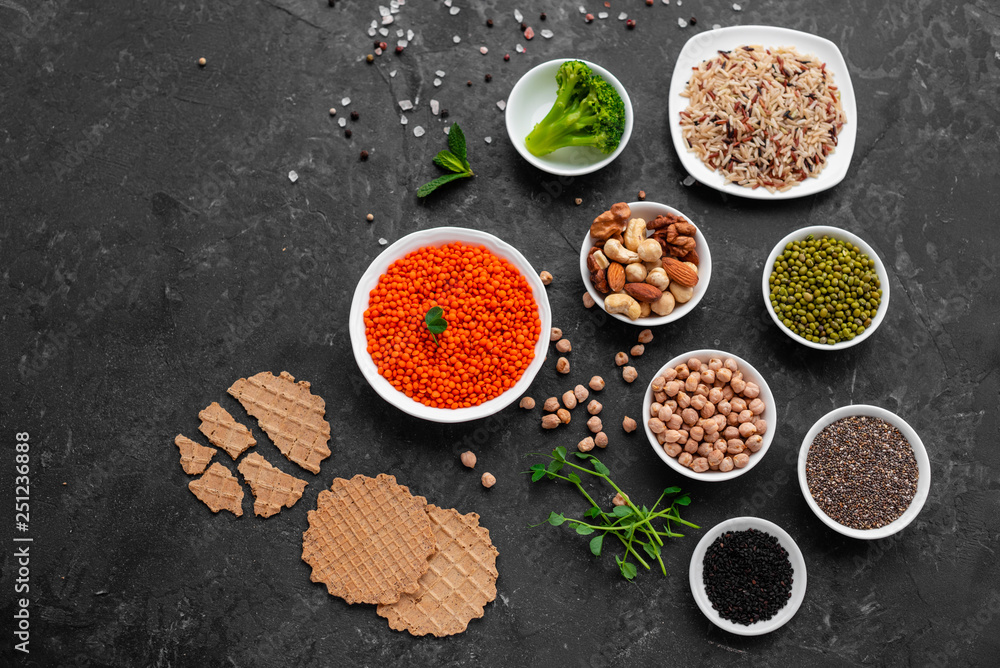 Superfoods on a gray background with copy space. Nuts, beans, greens and seeds. Healthy vegan food Superfoods on a gray background with copy space. Nuts, beans, greens and seeds. Healthy vegan food