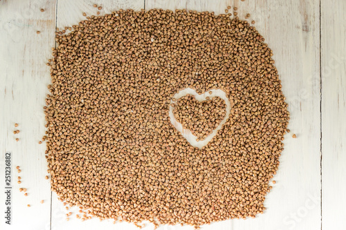 buckwheat background with drawn heart. Gluten free and healthy diet. Shallow depth of field. © IKvyatkovskaya