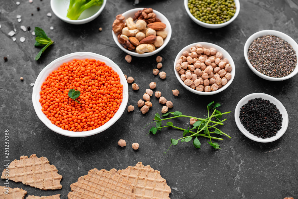 Superfoods on a gray background with copy space. Nuts, beans, greens and seeds. Healthy vegan food Superfoods on a gray background with copy space. Nuts, beans, greens and seeds. Healthy vegan food