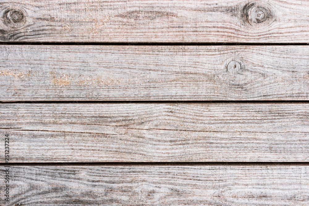 Fototapeta premium Wooden background. Boards in the sand. Wooden walkway on the sandy beach. Natural materials. The texture of the wooden surface. Beach landscape.